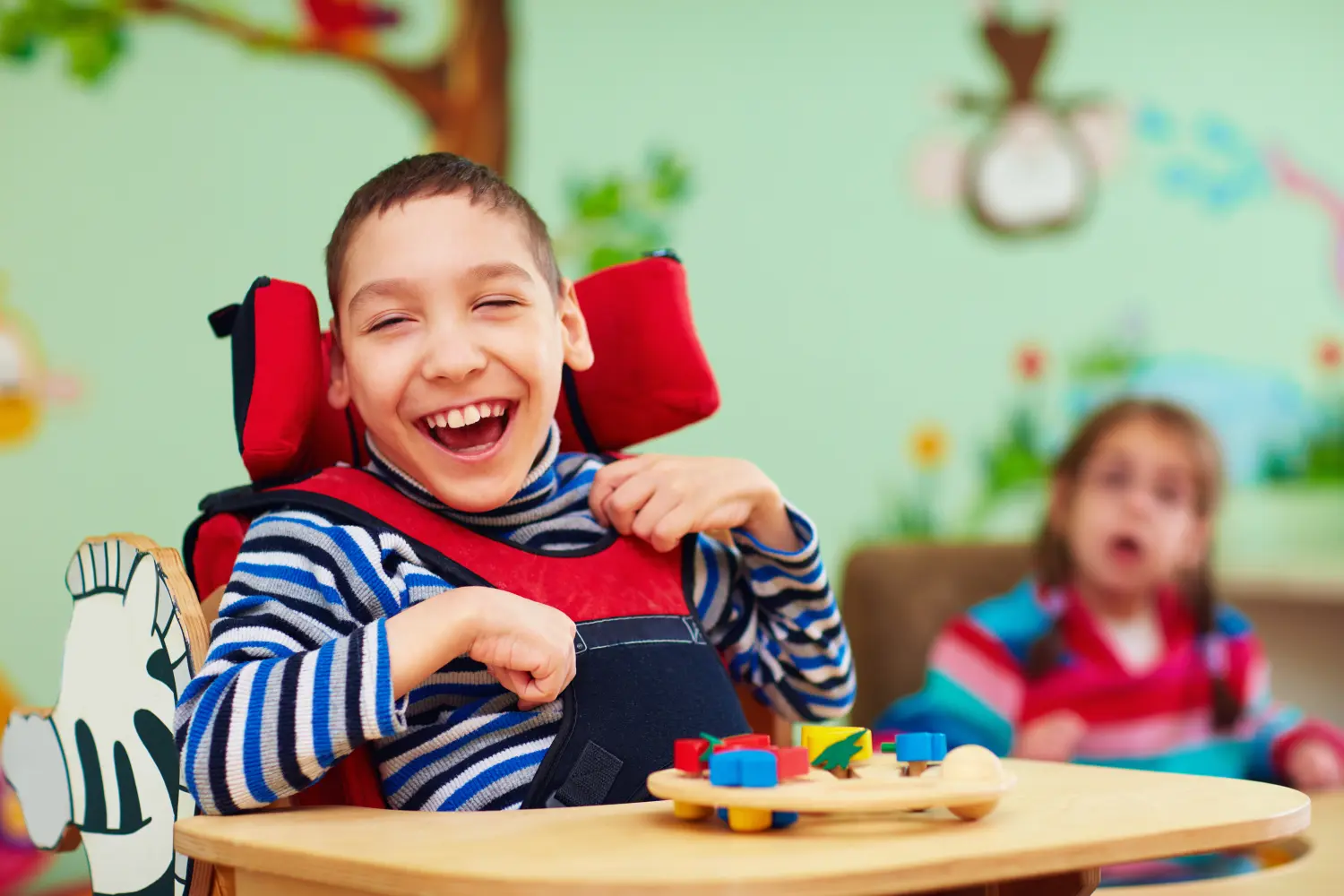 Fröhlicher Junge mit Behinderung in einem Rehabilitationszentrum für Kinder mit besonderen Bedürfnissen.